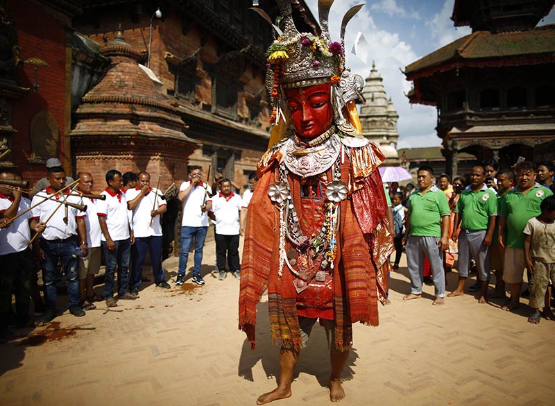 Revellers play musical instruments while a man in the costumes and as the idol of Dipankar Buddha marchs around the ancient city during Pancha Daan festival, in Bhaktapur, on Wednesday, August 28, 2019. Photo: Skanda Gautam/THT