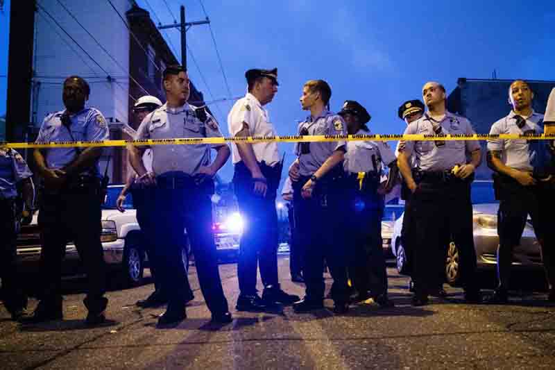 Officers gather for crowd control near a massive police presence set up outside a house as they investigate a shooting in Philadelphia, Wednesday, August 14, 2019. Photo: AP
