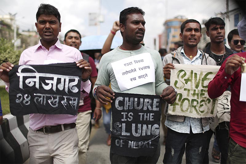 Activists shout slogans carrying banners of save trees during a protest outside Civil Aviation Authority of Nepal, in Kathmandu, on Monday, August 19, 2019. Photo: AP