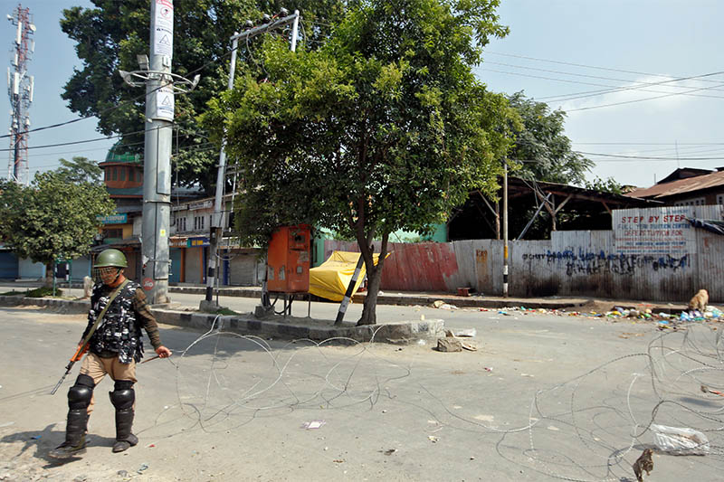 An Indian policeman lays concertina wire across a road during restrictions in Srinagar August 6, 2019. Photo: Reuters