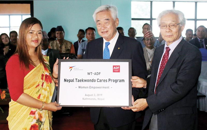 WTF President Chungwon Choue (centre) handing over the Women Empowerment banner to Founder of Genesis Academy Russ Lama during the inauguration of the World Taekwondo Cares Project in Lalitpur on Saturday. Photo: THT