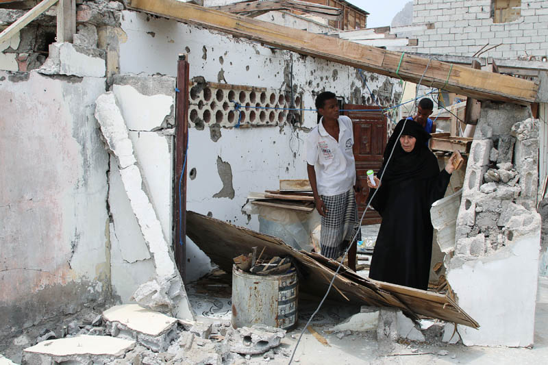 A woman checks her house damaged during clashes between separatists and government forces in Aden, Yemen August 13, 2019. Photo: Reuters