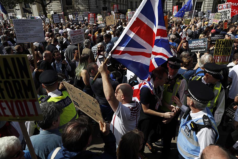 Brexit supporters surrounded by policemen hold British flags as anti Brexit protesters demonstrate during a rally outside Downing Street in London on August 31, 2019. Photo: AP