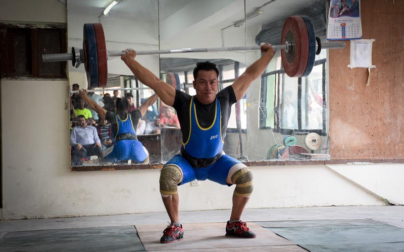 Bikash Thapa lifts weight during the selection tournament in Kathmandu on Sunday, September 2, 2019.Photo: THT