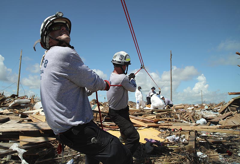 Members of the fire rescue team Task Force 8, from Gainesville, Florida, help remove a body one week after Hurricane Dorian hit The Mudd neighborhood in the Marsh Harbor area of Abaco Island, Bahamas, Monday, on Sept. 11, 2019. Photo: AP