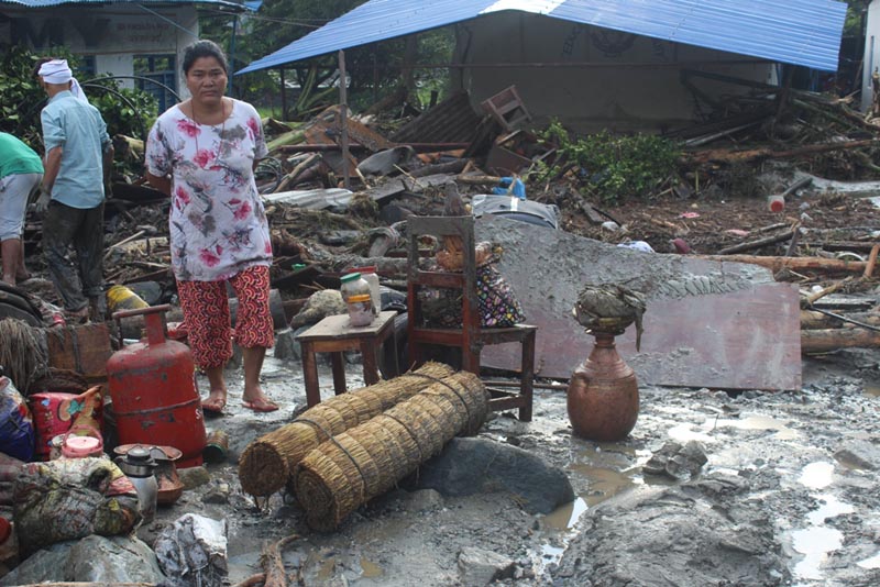 A woman looking at her belongings after a flood in Kotkhola river entered the settlement of Beni Municipality-2 in Mygadi district on Sunday, September 22, 2019. Photo: Rishi Ram Baral/THT