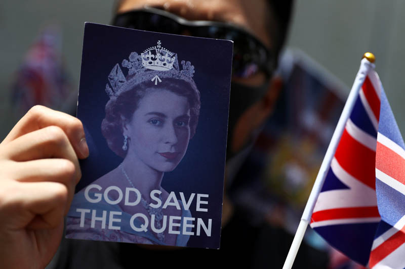 An anti-government protester holds up a Union Jack flag and a placard with a likeness of Queen Elizabeth at the British consulate General in Hong Kong, China, September 15, 2019.  Photo: Reuters