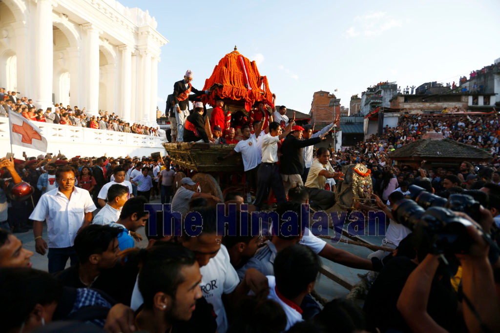 FILE - Nepali devotees pull a chariot of the Living Goddess 'Kumari' during Indra Jatra festival, celebrated to honour Indra, the King of Heaven and Lord of Rains, in Kathmandu, Nepal, on Monday, September 24, 2018. Indra Jatra is the biggest religious street festival held annually in Kathmandu Valley. The festival is celebrated by singing, dancing, rejoicing, and both Hindu and Buddhist devotees offering prayers along with other rituals. Photo: Skanda Gautam/THT