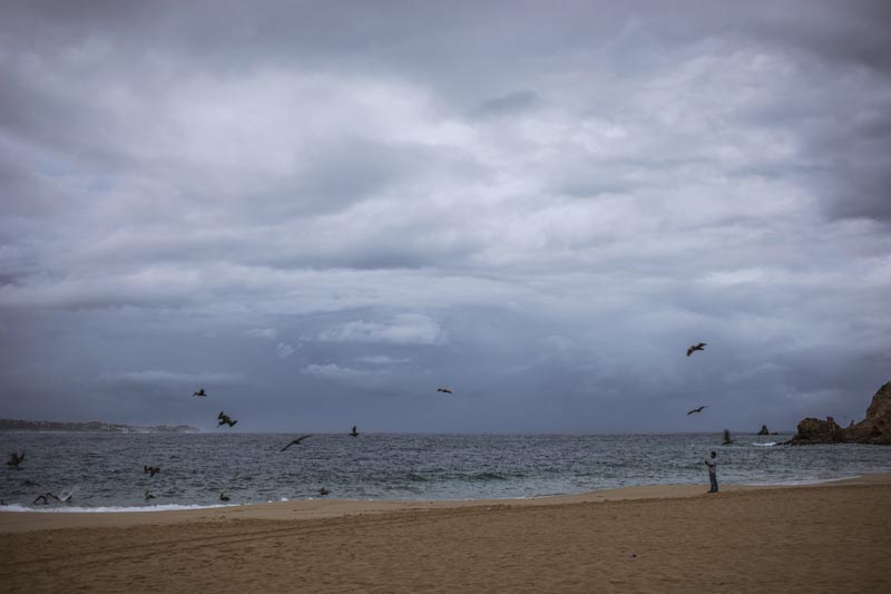 A tourist walks on the beach before the expected arrival of Hurricane Lorena, in Los Cabos, Mexico, Friday, Sept 20, 2019. Photo: AP