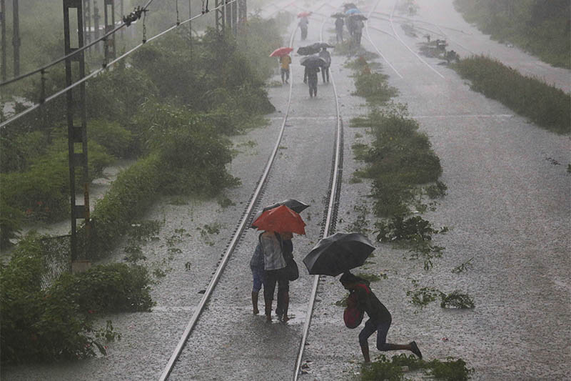 Commuters walk on a flooded railway track after a heavy rainfall in Mumbai, India, September 4, 2019. Photo: Reuters