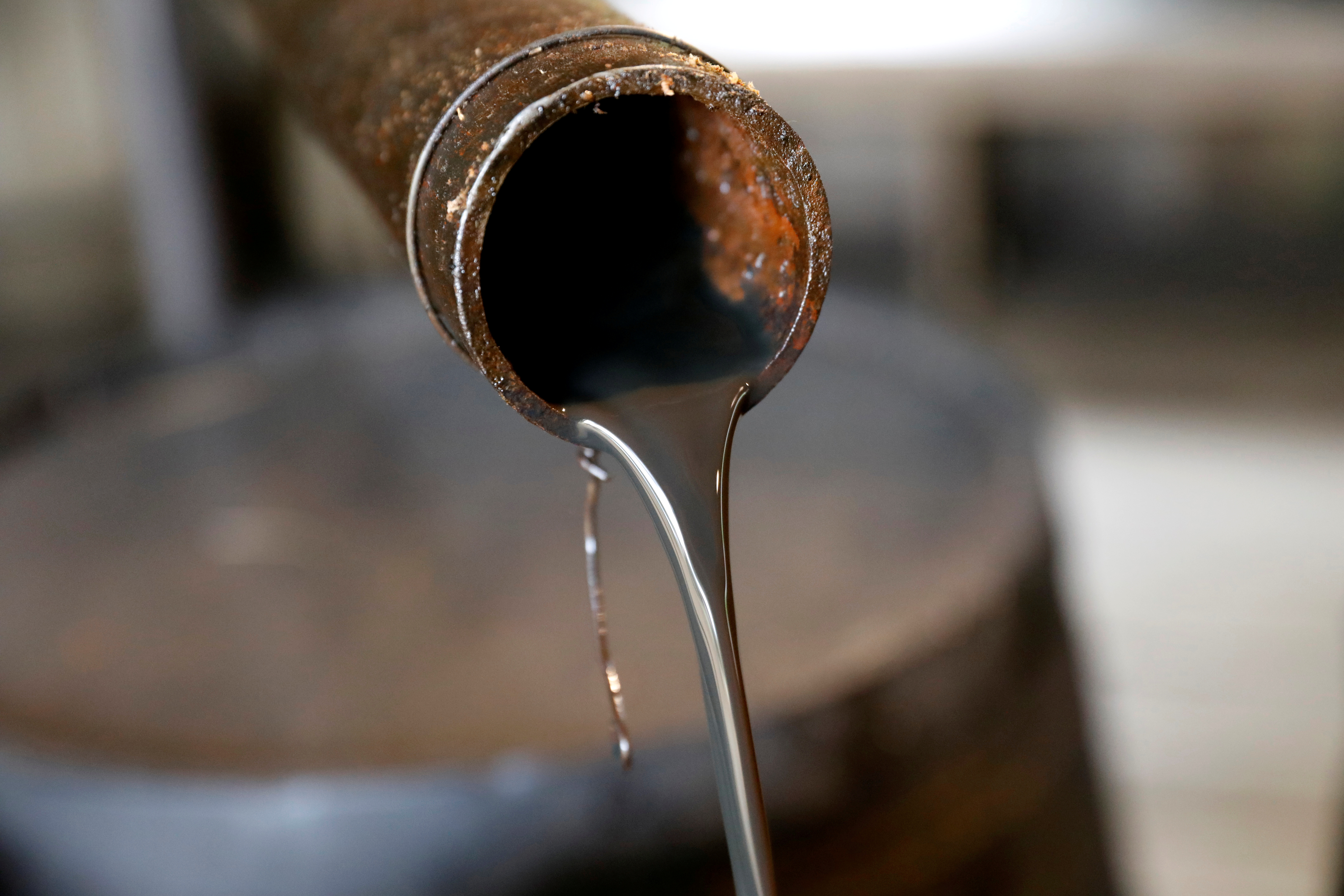 FILE PHOTO: Oil pours out of a spout from Edwin Drake's original 1859 well that launched the modern petroleum industry at the Drake Well Museum and Park in Titusville, Pennsylvania U.S., October 5, 2017. REUTERS/Brendan McDermid/File Photo