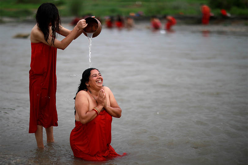 Nepali women perform a ritual as they take a holy bath in the Manahara River during the Rishi Panchami festival in Kathmandu, Nepal, September 3, 2019. Rishi Panchami is observed on the last day of Teej when women worship Sapta Rishi (Seven Saints) to ask for forgiveness for sins committed during their menstrual period throughout the year. The Hindu religion considers menstruation as a representation of impurity and women are prohibited from taking part in religious practices during their monthly menstruations. Photo: Reuters