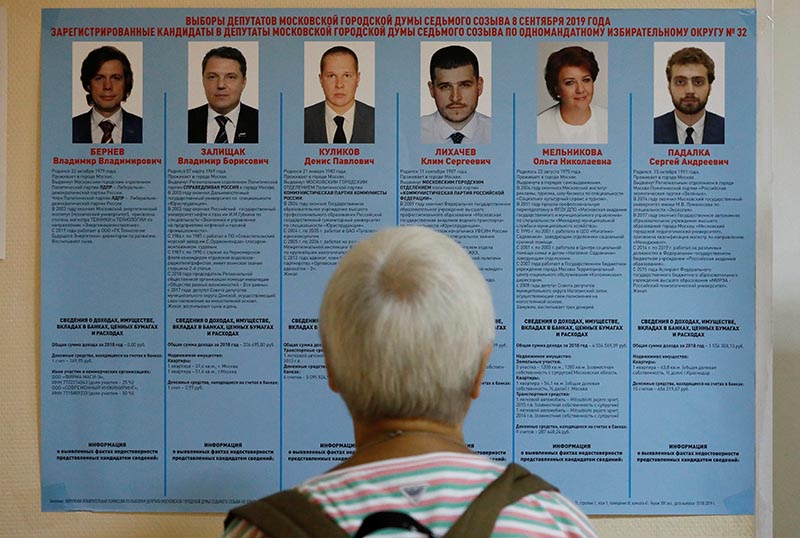 A voter studies a candidate information broadsheet at a polling station during the Moscow city parliament election in Moscow, Russia September 8, 2019. Photo: Reuters