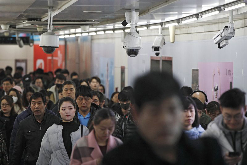 FILE - In this Feb. 26, 2019, file photo commuters walk by surveillance cameras installed at a walkway in between two subway stations in Beijing. The Carnegie Endowment for International Peace released a report Tuesday, Sept. 17, that found at least 75 countries are actively using AI tools such as facial recognition for surveillance. The new report says a growing number of countries are following Chinau0092s lead in deploying artificial intelligence to track citizens. Photo: AP