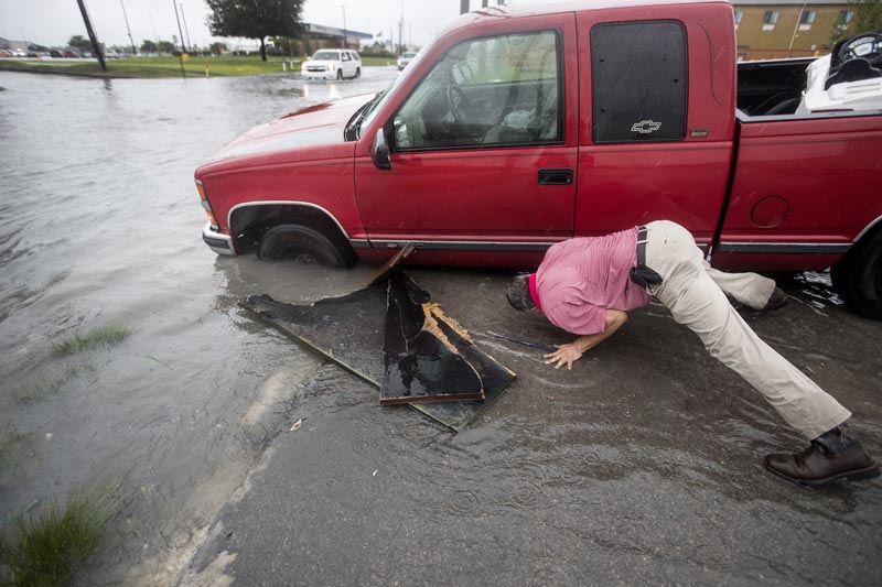 Felipe Morales works on getting his truck out of a ditch filled with high water during a rain storm stemming from rain bands spawned by Tropical Storm Imelda on Tuesday, September 17, 2019, in Houston. Photo: Brett Coomer/Houston Chronicle via AP