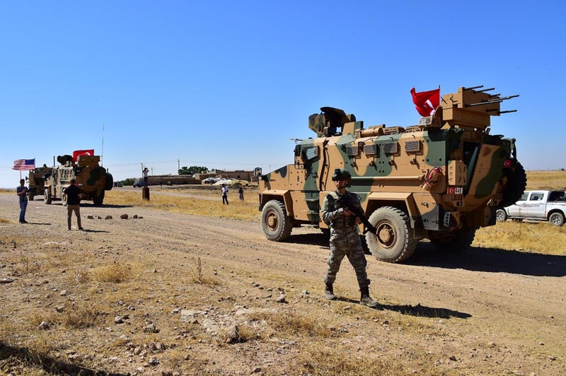 Turkish and US military vehicles are seen during a joint US-Turkey patrol in a Syrian border village near Tel Abyad, Syria, September 8, 2019.Turkish Defence Ministry/Handout via Reuters