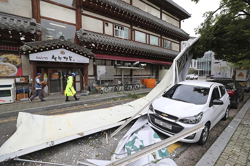 A vehicle is damaged by fallen signboard from a building as Typhoon Lingling brings strong wind and rain in Seoul, South Korea, Saturday on September 7, 2019. Photo: AP
