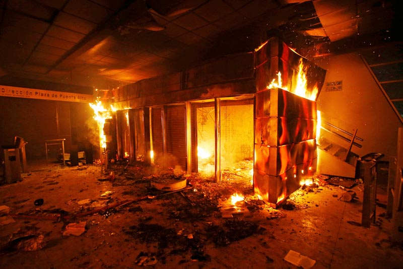A subway ticket office is seen on fire during a protest against the increase in the subway ticket prices in Santiago, Chile, October 19, 2019. Photo: Reuters
