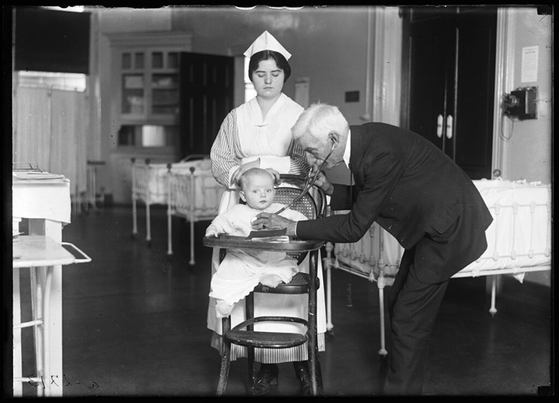 In this 1915-1923 photo made available by the Library of Congress, a doctor examines a child with a stethoscope, accompanied by a nurse, in the United States. Two centuries after its invention, the stethoscope -- the very symbol of the medical profession -- is facing an uncertain prognosis. Photo: Library of Congress via AP