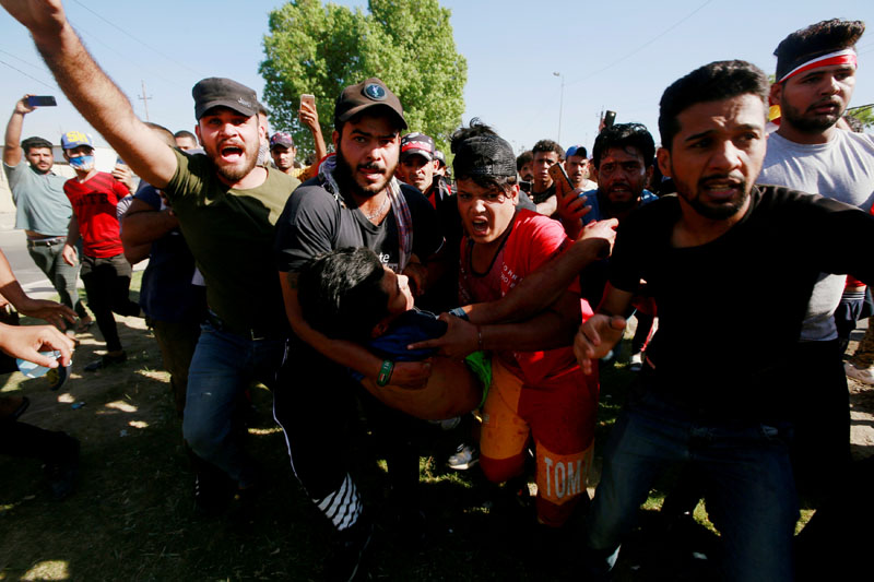 Men carry an injured demonstrator at a protest during a curfew, three days after the nationwide anti-government protests turned violent, in Baghdad, Iraq October 4, 2019. Photo: Reuters/File