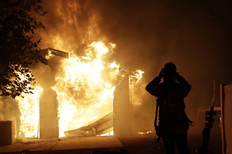 A firefighter prepares to fight a wildfire as it overtakes a home Thursday, October 24, 2019, in Santa Clarita, California. Photo: AP