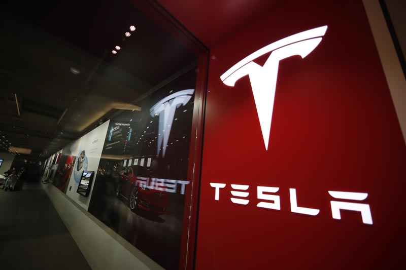 FILE- In this February 9, 2019, file photo, a sign bearing the company logo is displayed outside a Tesla store in Cherry Creek Mall in Denver. Photo: AP