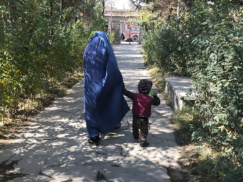 A woman and a child walk in a park that is being upgraded with wider footpaths, more lights and seating areas as part of a programme to make public spaces safer and more accessible for women in Kabul, Afghanistan. November 6, 2019. Photo: Thomson Reuters Foundation