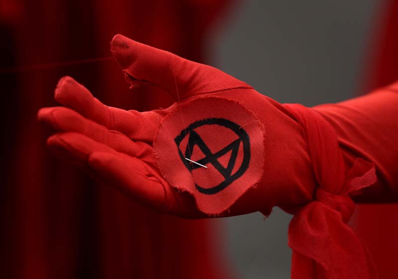 An Extinction Rebellion logo is seen on the gloved hand of a climate change protester in London, Wednesday, Oct 9, 2019.  Photo: AP/File
