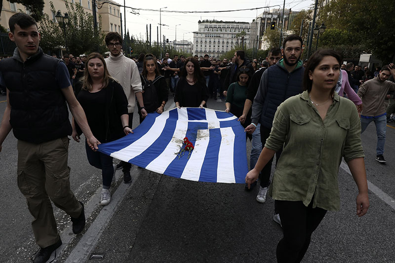 University students hold a blood-stained Greek flag from the deadly 1973 student uprising during a rally in Athens, Sunday, Nov. 17, 2019. Photo Courtesy: AP