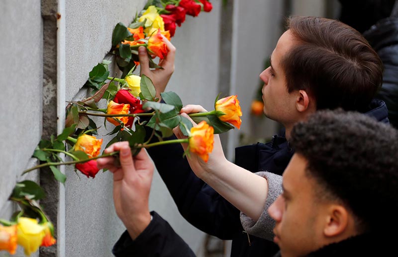 People place roses at the Wall memorial during a ceremony marking the 30th anniversary of the fall of the Berlin Wall at Bernauer Strasse in Berlin, Germany November 9, 2019. Photo: Reuters