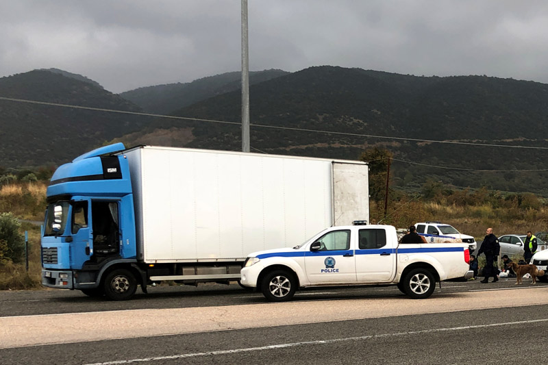 Police officers stand next to a refrigerated truck carrying migrants, after a check at a motorway near Xanthi Greece, November 4, 2019. Photo: Reuters