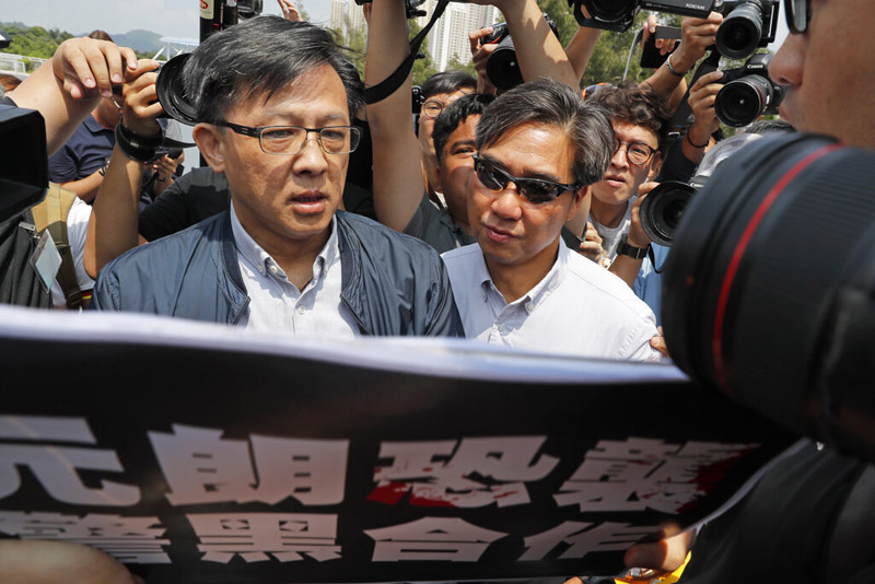 In this August 12, 2019, photo, pro-Beijing lawmaker Junius Ho, left, attends a demonstration of an anti-riot vehicle equipped with water cannon at the Police Tactical Unit Headquarters in Hong Kong. Photo: AP