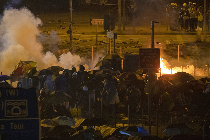 Protesters battle against riot police firing tear gas outside the Hong Kong Polytechnic University, in Hong Kong, on  Monday, November 18, 2019. Fiery explosions were seen early Monday as Hong Kong police stormed into the university held by protesters after an all-night standoff. Photo: AP