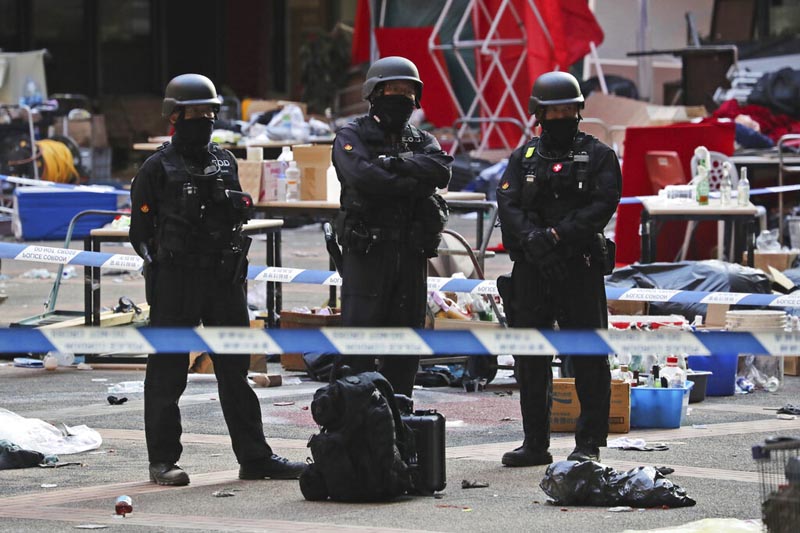 Bomb disposal police watch from a cordoned area as evidence is collected in a cordoned off area in the Polytechnic University campus in Hong Kong, Thursday, November 28, 2019. Photo: AP