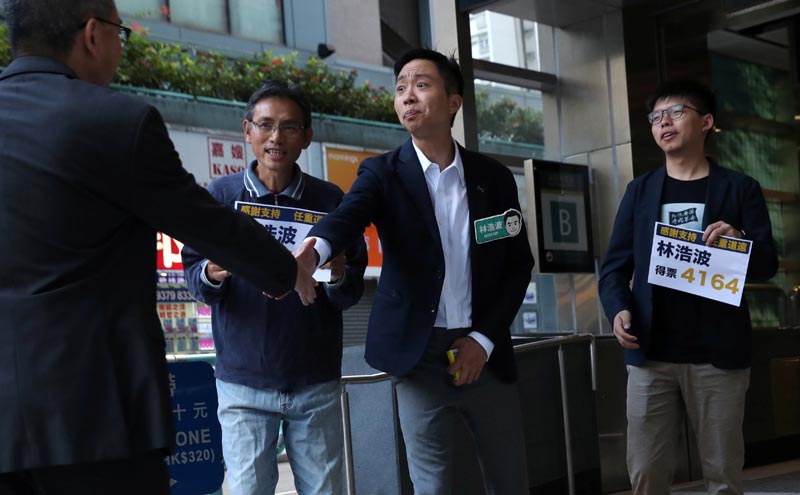 Winning candidate Kelvin Lam and activist Joshua Wong greet people and thank them for their support, outside of South Horizons Station, in Hong Kong, China, November 25, 2019, the morning after Lam won in district council elections. Photo: Reuters