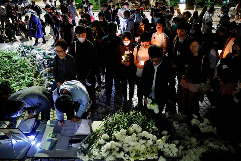 Students pay tribute with flowers to Chow Tsz-lok, 22, a university student who fell during protests at the weekend and died early on Friday morning, at the Hong Kong University of Science and Technology, in Hong Kong, China November 8, 2019. Photo: Reuters