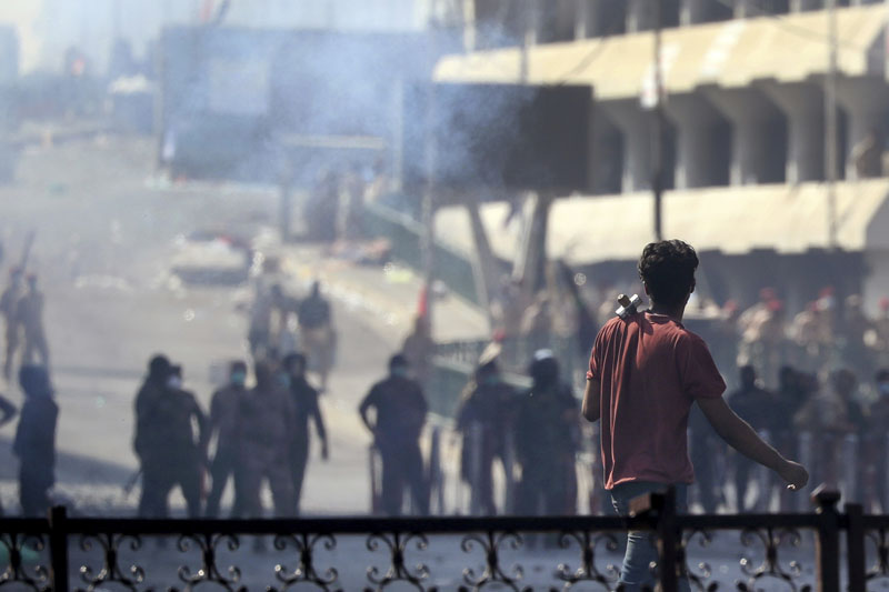 Iraqi riot police fire tear gas to disperse anti-government protesters gathering on bridge in central Baghdad, Iraq, Saturday, Nov 9, 2019. Photo: AP