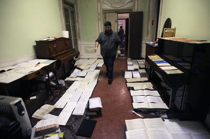 Volunteers try to save ancient music sheets by placing them to dry at the first floor of Venice Conservatory after recovering them from ground floor, Italy, Saturday, Nov 16, 2019. Photo: AP