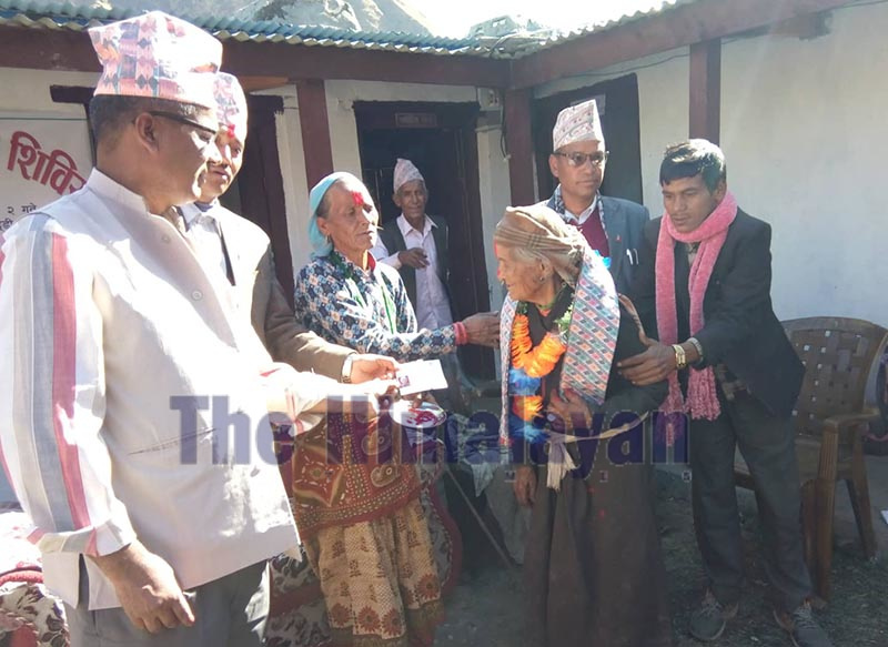 Kalya Baduwal, 96, of Jagannath Rural Municipality receiving citizenship certificate at a mobile camp that was organised at the rural municipality, in Bajura, on Wednesday. Photo: THT