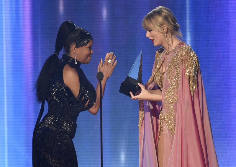 Regina King, left, presents the award for artist of the year to Taylor Swift at the American Music Awards on Sunday, November 24, 2019, at the Microsoft Theatre in Los Angeles. Photo: AP