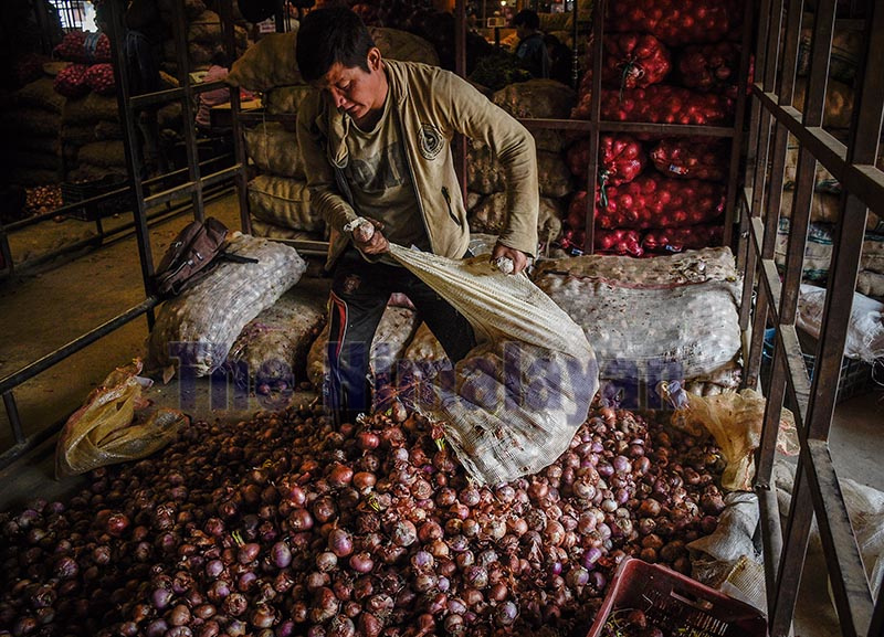 A man arranges onions for packing at her wholesale stall in Kalimati vegetable market, Kathmandu on Tuesday. Photo: Naresh Shrestha/ THT