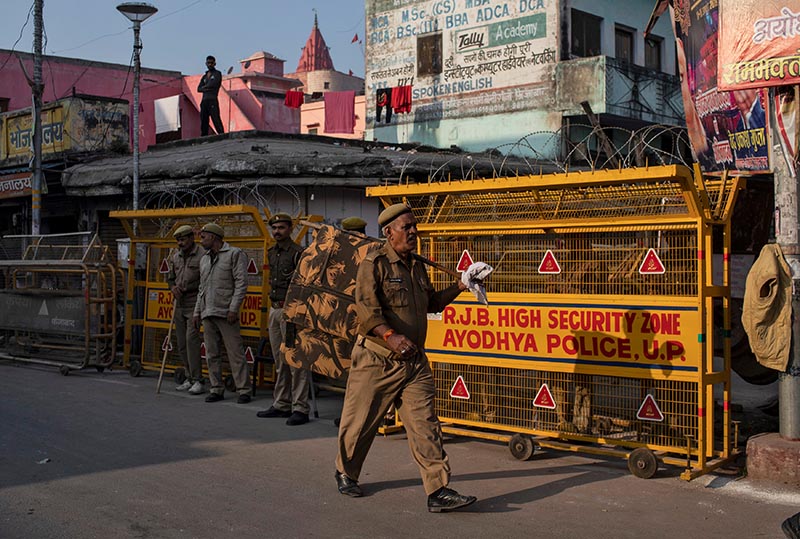 A police officer walks past a security barricade as others stand guard near a temple after Supreme Court's verdict on a disputed religious site, in Ayodhya, India, November 10, 2019. Photo: Reuters