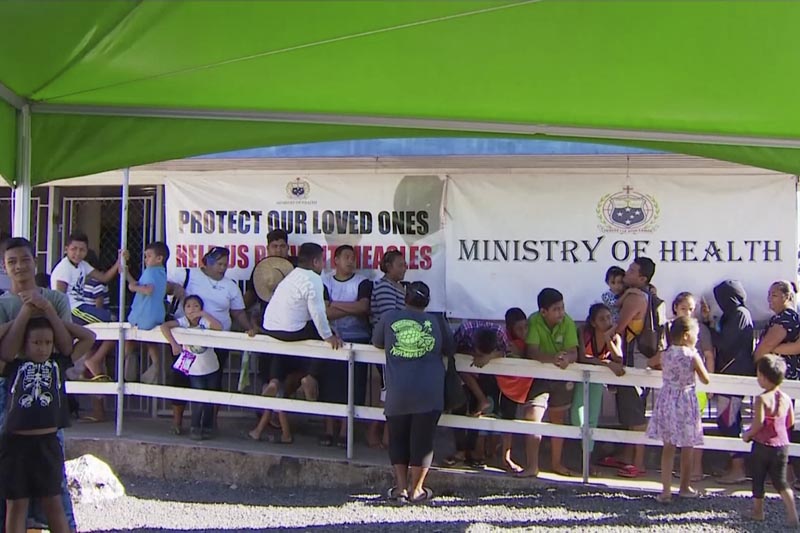 Children with parents wait in line to get vaccinated outside a health clinic in Apia, Samoa. Samoa closed all its schools on Monday, Nov 18, 2019, banned children from public gatherings and mandated that everybody get vaccinated after declaring an emergency due to a measles outbreak, November 2019. Photo: TVNZ via AP