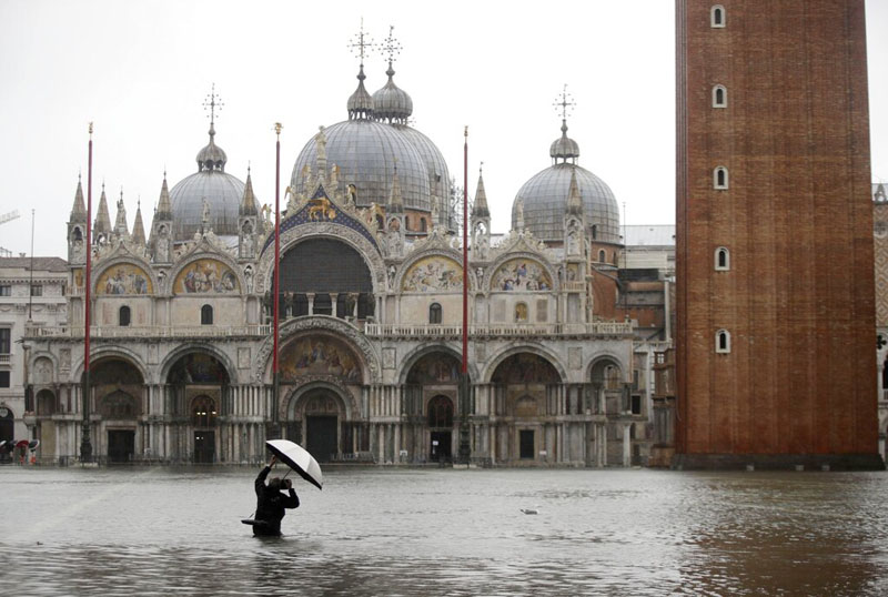 A photographer takes pictures in a flooded St. Mark's Square, in Venice, Italy, Tuesday, November 12, 2019. Photo: Reuters