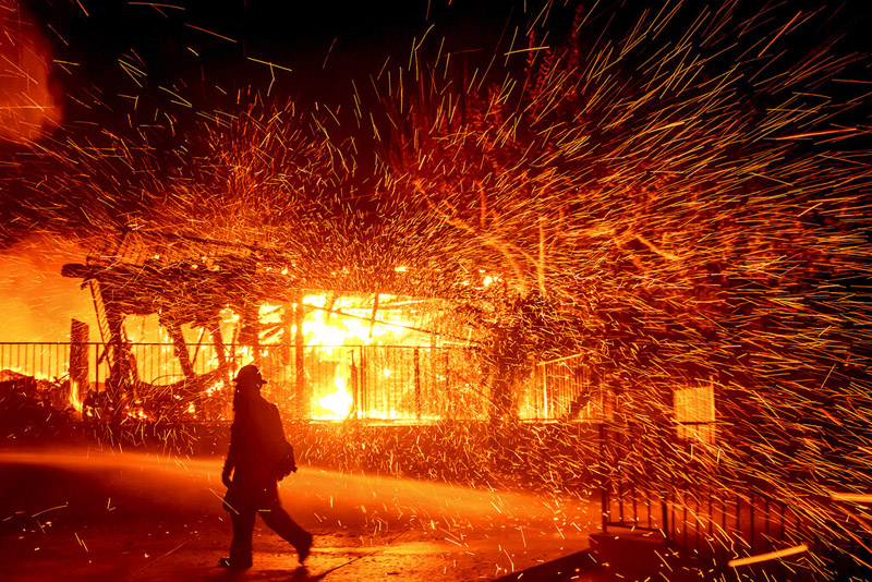 A firefighter passes a burning home as the Hillside fire burns in San Bernardino, California, October 31, 2019. Photo: AP