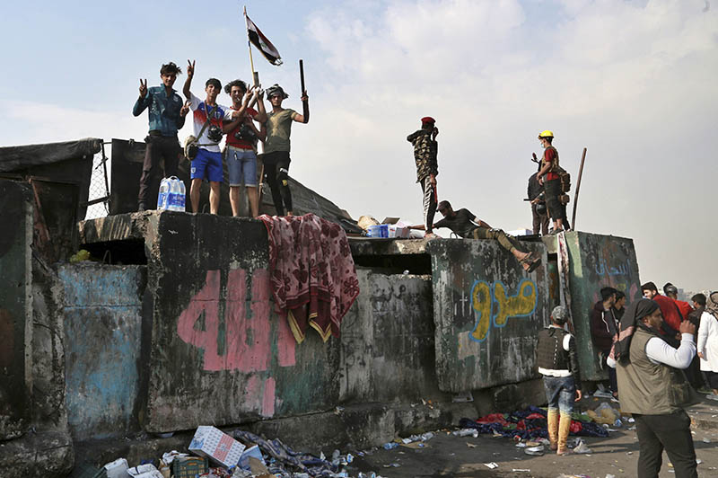 Protesters stage a sit-in on barriers at the Ahrar Bridge during ongoing anti-government protests in Baghdad, Iraq, Wednesday, Nov. 27, 2019. Photo: AP