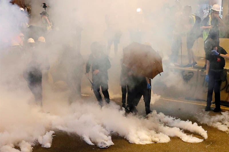 FILE PHOTO: Anti-extradition bill demonstrators react as riot police fire tear gas after a march to call for democratic reforms, in Hong Kong, China July 21, 2019. Photo: Reuters