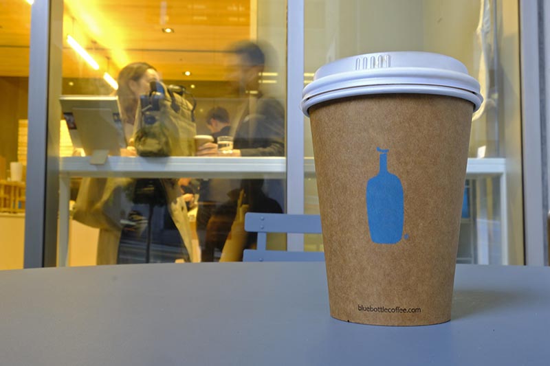 A Blue Bottle Coffee paper to-go cup rests on a table outside one of their cafes in San Francisco, on Thursday, December 12, 2019. Photo: AP