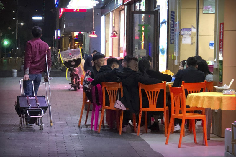 In this Dec. 6, 2019, photo, Wu Yi, who has struggled with Oxycontin abuse, wheels his portable amplifier past customers at an all-night restaurant in Shenzhen in southern China's Guangdong Province. Officially, pain pill abuse is an American problem, not a Chinese one. But people in China have fallen into opioid abuse the same way many Americans did, through a doctor's prescription. And despite China's strict regulations, online trafficking networks, which facilitated the spread of opioids in the U.S., also exist in China. Photo: AP