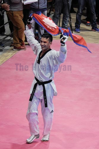 Taekwondo player Bir Bahadur Mahara celebrates after winning a gold medal in 13th South Asian Games in Lalitpur on Tuesday, December 3, 2019. Photo: THT